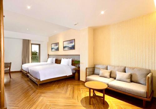 a hotel room with a bed and a couch at Khách Sạn Homestay LaMera in Ben Tre