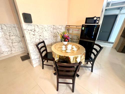 a dining room with a table and chairs with flowers on it at Khách Sạn Homestay LaMera in Ben Tre