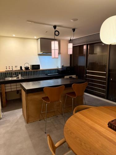 a kitchen with a counter and a table and chairs at Chayado 百八 善光寺門前 in Nagano