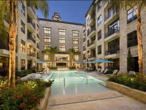 a swimming pool in front of a building at Galleria King Luxury Suite - Walk to Mall - Pool View in Houston