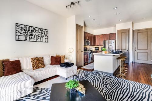 a living room with a zebra print couch and a kitchen at Galleria King Luxury Suite - Walk to Mall - Pool View in Houston