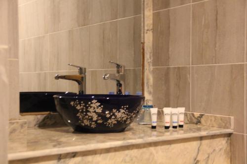 a bathroom with a black bowl sink and a mirror at Casablu Hotel in Nouakchott