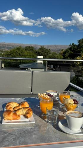 a table with two plates of croissants and orange juice at Sol del Valle in Mina Clavero