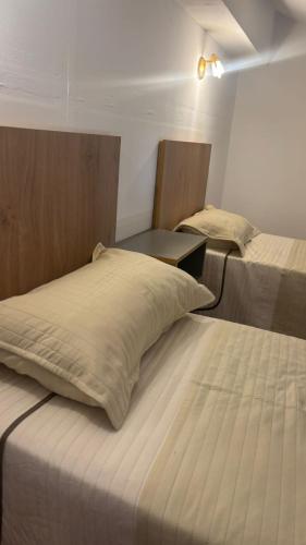 a room with two beds and a table in it at Sol del Valle in Mina Clavero