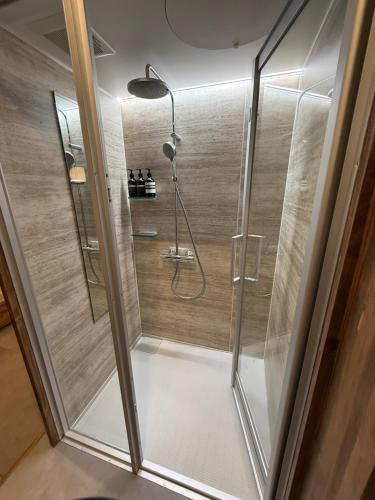 a shower with a glass door in a bathroom at Chayado 百八 善光寺門前 in Nagano