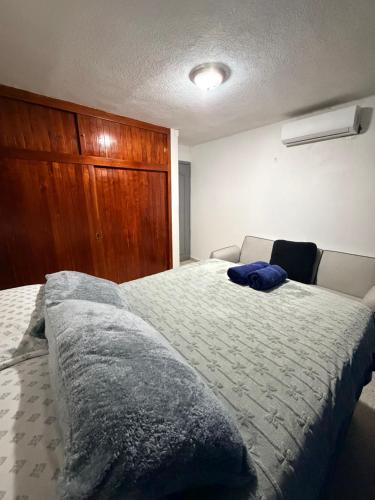 a bedroom with a large bed and a wooden cabinet at Cómodo departamento en planta baja con dos recámaras in Villahermosa