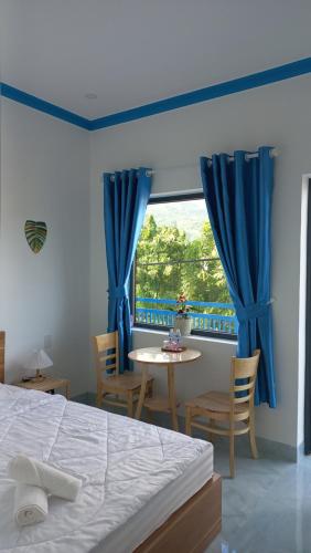 a bedroom with a bed and a table and a window at Homestay xóm nhỏ in Ninh Hải