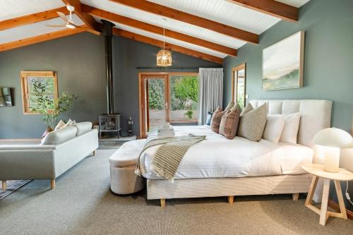 a bedroom with a large white bed and a couch at Buffalo Bliss in Porepunkah