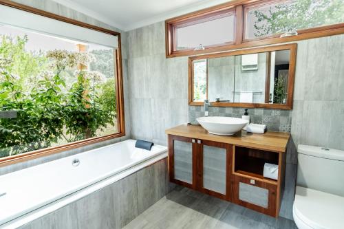 a bathroom with a tub and a sink and a window at Buffalo Bliss in Porepunkah
