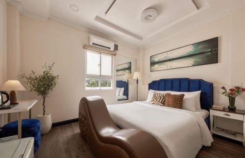 a bedroom with a large bed and a chair at Quy Hung Hotel - Ben Thanh Market in Ho Chi Minh City