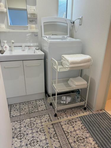 a small white bathroom with a sink and a toilet at Style Room in Osaka