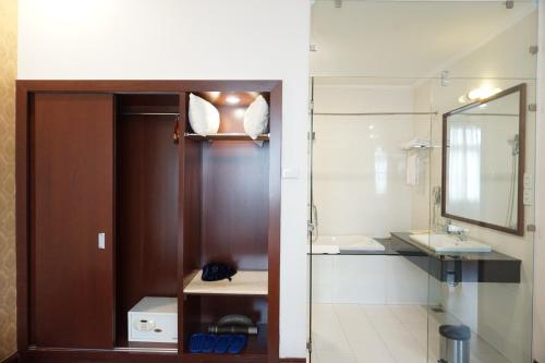 a bathroom with a door and a sink and a mirror at Dong Khanh Hotel in Ho Chi Minh City