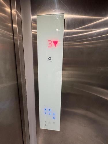 a lightswitch on the side of a metal refrigerator at R Square Homes in Bangalore