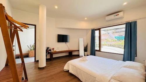 a bedroom with a bed and a large window at Leranda Bonita in Hue