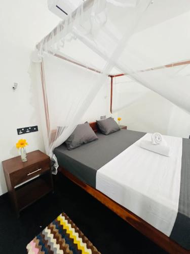 a bedroom with a bed and a nightstand and a bed sidx sidx sidx sidx at silent beach House For Ever in Tangalle