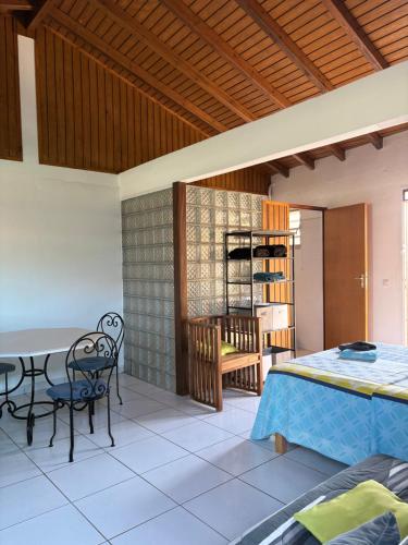 una stanza con un letto, un tavolo e delle sedie di LABé KAZ Kréyòl Studio a Le Moule