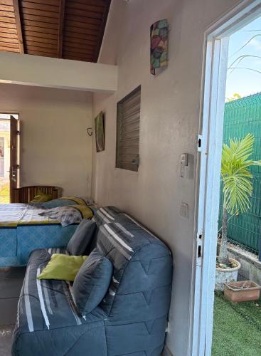 una camera da letto con un letto e un divano accanto a una finestra di LABé KAZ Kréyòl Studio a Le Moule