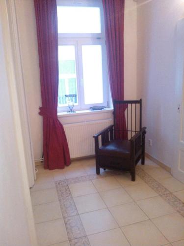 a room with a chair in front of a window at Pension Villa Anita in Mariánské Lázně