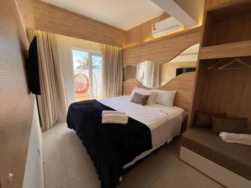 a small bedroom with a bed and a balcony at Beira-Mar Sofisticado com Vista Mar e Piscina in Pontal do Paraná
