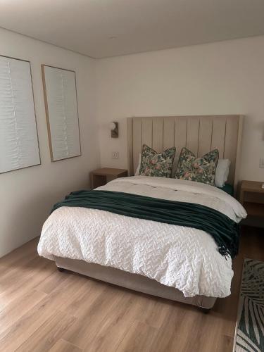 a bedroom with a large bed with white sheets and pillows at Two Tides in Ballito