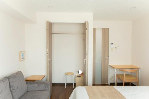 a bedroom with a bed and a couch and a table at Planetarium N in Yamashitachō