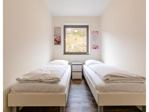 two beds in a room with a window at Bungalow im Campingpark in Waxweiler