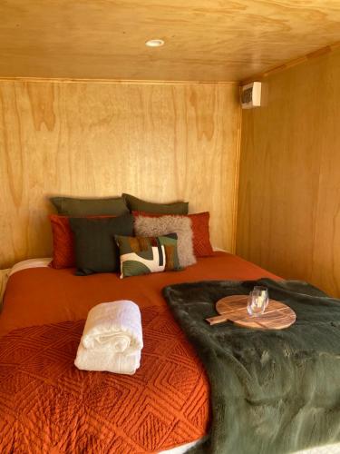 a large bed in a small room with a bedspread at Ruapehu Views Cabin Getaway in Raetihi
