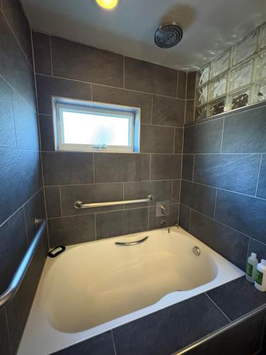 a bath tub in a bathroom with a window at High Moon 4 Ten Thousand Waves Way in Santa Fe