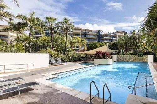 a large swimming pool in front of a building at Beachside 1-Bedroom Apartment -Alex and Mooloolaba in Maroochydore