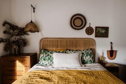 a bedroom with a bed with a gold bedspread and a pillow at Moonbird Beach Shack ~ Ocean Escape in Beaumaris Tasmania