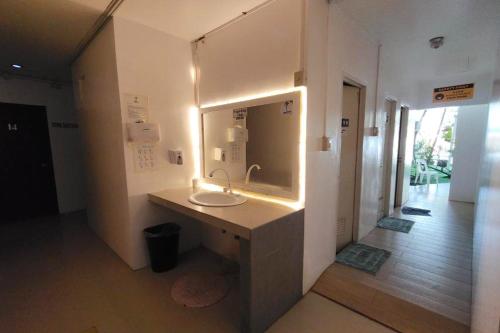 ein Badezimmer mit Waschbecken und Spiegel in der Unterkunft Boracay Backpackers in Boracay