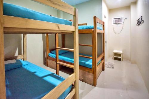 ein Zimmer mit drei Etagenbetten mit blauen Laken in der Unterkunft Boracay Backpackers in Boracay
