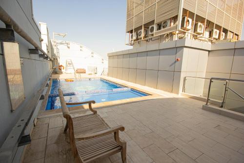 a bench next to a swimming pool on a building at Furnished Studio Near Burjuman Metro station in Dubai