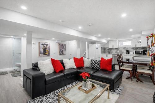 a living room with a black couch and red pillows at New 2BR Suite, Walk to Dining, Near Downtown in Calgary