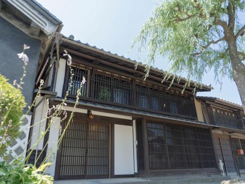 a building with a gate and a tree at 海野宿一棟貸し宿 上州屋 Unnojuku Joshuya in Tomi