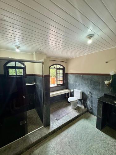 a large bathroom with a toilet and a shower at Sítio Castelo Branco - Morretes in Morretes