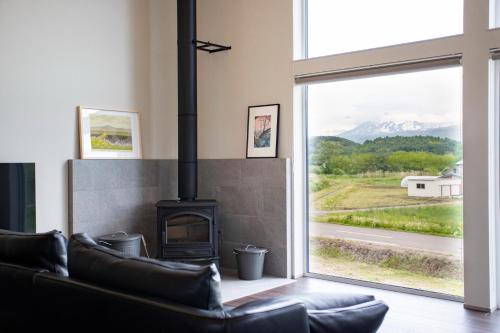 a living room with a fireplace and a window at Villa HIGASHIKAWA -Hokkaido- in Higashikawa