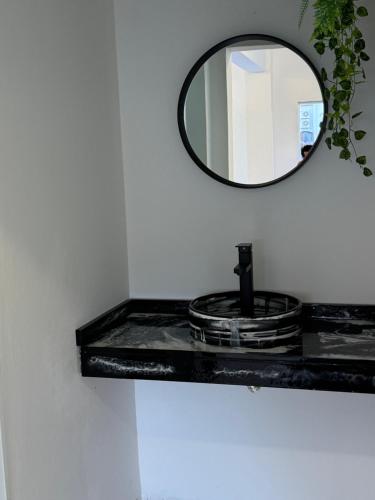 a bathroom with a black counter with a mirror at LakeHouse Hotel & Suites in Villa Carlos Paz