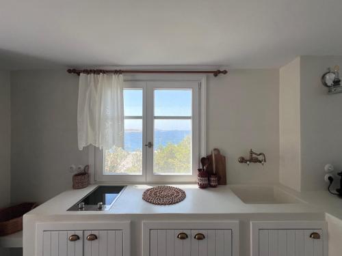 a kitchen with a sink and a window at Kimoliatiko in Kimolos