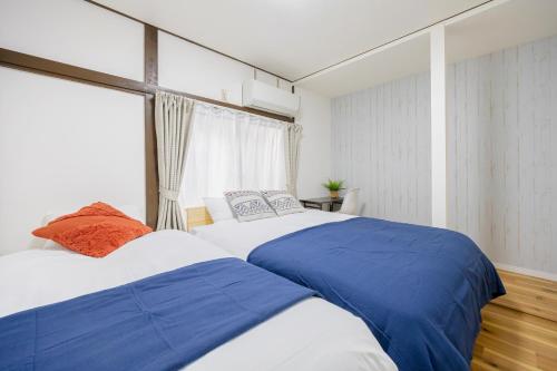 two beds in a bedroom with a window at -Shibamata House- 9-minute walk from Shibamata Station in Tokyo