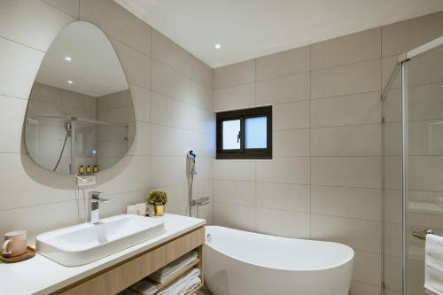 a white bathroom with a sink and a mirror at Mr Petter in Taichung
