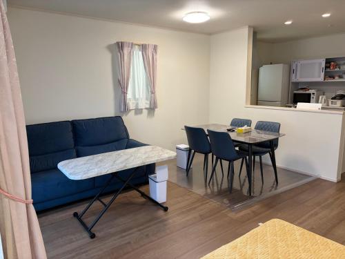 a living room with a blue couch and a table at Tokyo Koya Station on walk2mins新築別荘無料駐車場4LDK-free-wifi in Tokyo