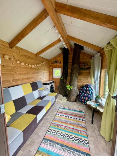 ein Wohnzimmer mit Sofa und Tisch in der Unterkunft Langaland Glamping unități de cazare în natură cu mic dejun și cină incluse in Susenii Bîrgăului