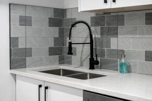 a kitchen counter with a sink in a kitchen at New 2BR Suite, Walk to Dining, Near Downtown in Calgary