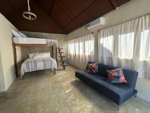 ein Wohnzimmer mit Sofa und Etagenbett in der Unterkunft Cabañas Tzikin, Telchac Puerto in Telchac
