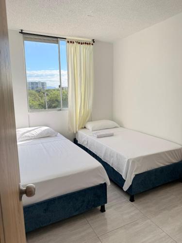 two beds in a room with a window at Apartamento Completo en Ricaurte in Ricaurte