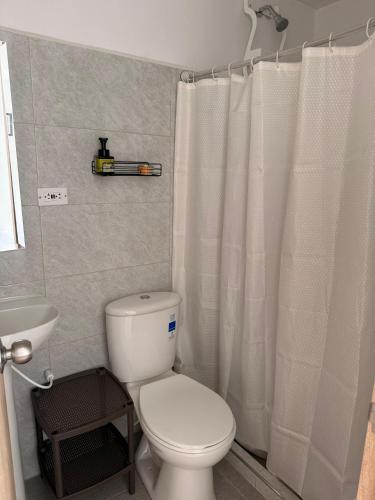a bathroom with a toilet and a shower curtain at Apartamento Completo en Ricaurte in Ricaurte
