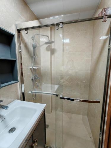 a shower with a glass door next to a sink at Raya's Staycation Megatower 7 Baguio City in Baguio