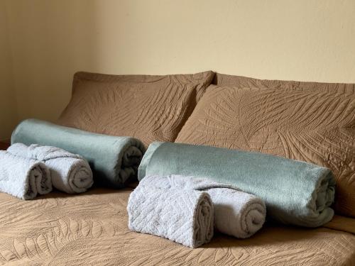 a bed with towels sitting on top of it at Loft Central Orgânico in Passos