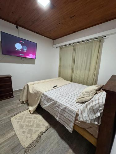a bedroom with a bed and a flat screen tv at Casa Maipu in Corrientes